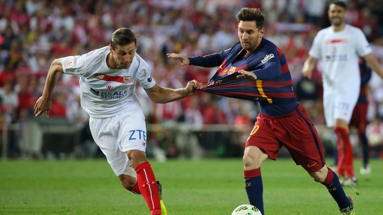 Sevilla midfielder Grzegorz Krychowiak (L) vies with Barcelona forward Lionel Messi