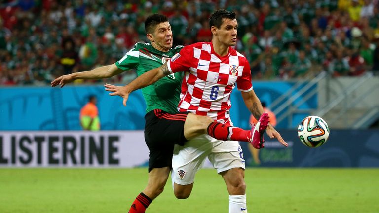 Oribe Peralta of Mexico challenges Dejan Lovren of Croatia during the 2014 FIFA World Cup Brazil Group A match between Croatia a