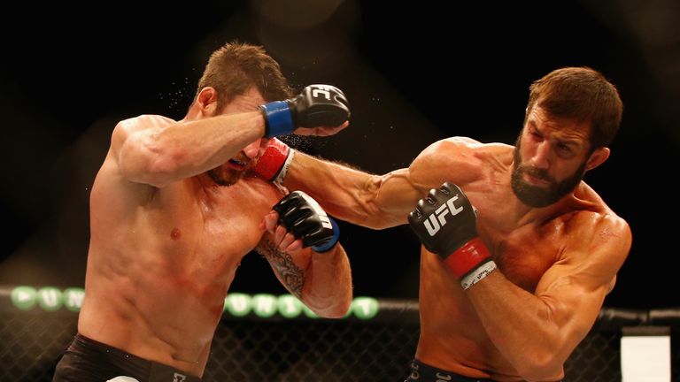 Luke Rockhold of the USA (R) connects with a right to the face of Michael Bisping of England in their middleweight fight 