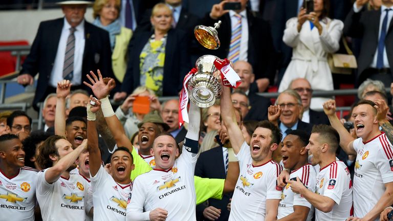 Wayne Rooney and Michael Carrick of Manchester United lift the trophy