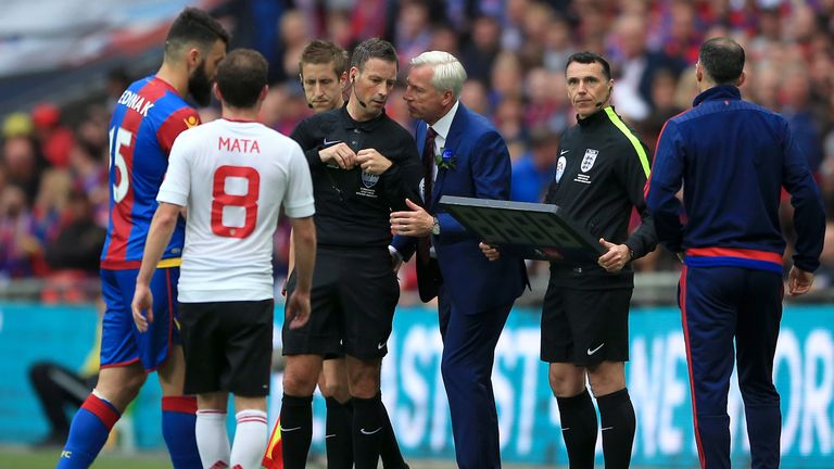Crystal Palace manager Alan Pardew (centre right) speaks with referee Mark Clattenburg (centre left) during the Emirates FA Cup Final at Wembley