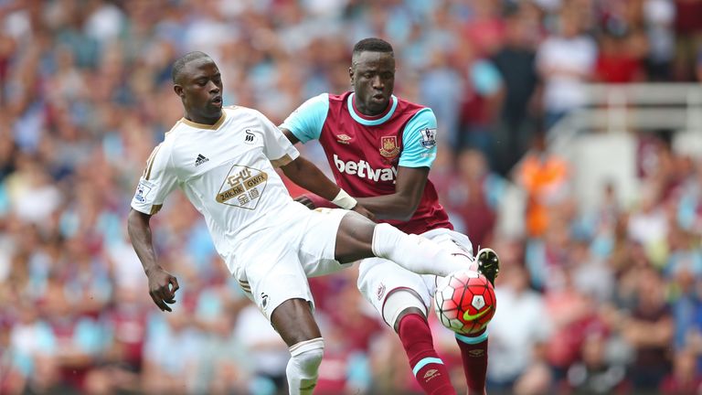 Modou Barrow of Swansea and Cheikhou Kouyate of West Ham compete for the ball 