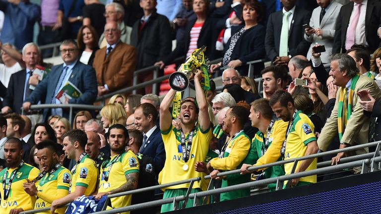 Norwich City's Scottish defender Steven Whittaker (C) raises the trophy 