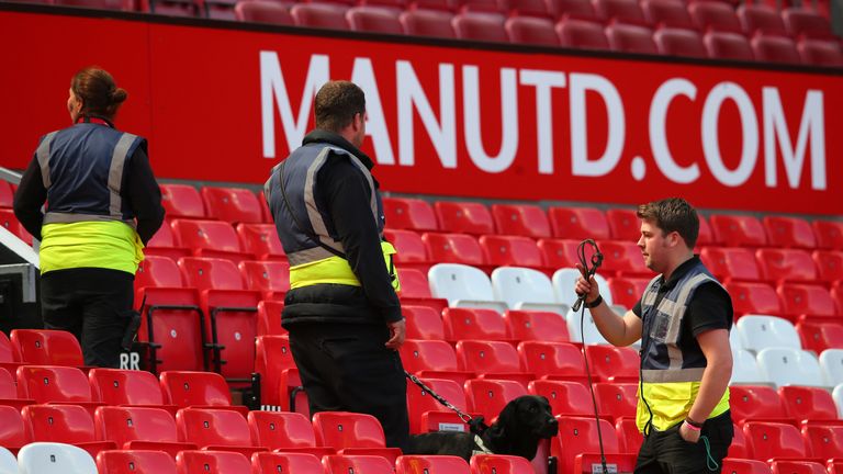 A sniffer dog patrols the stands as Man Utd v Bournemouth is abandoned with fans evacuated from Old Trafford