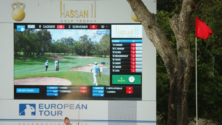 Paul Dunne of Ireland chip onto the 18th green in front of the scoreboard during the third round of the Trophee Hassan II at Roya