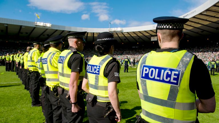Police line the pitch after the pitch invasion by Hibernian fans following the Scottish Cup final 