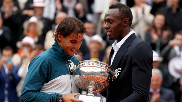 Rafael Nadal of Spain is presented with the Coupe des Mousquetaires trophy by Usian Bolt after the men's singles final against Da