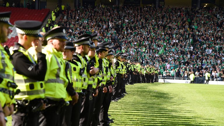 Police line the pitch at full-time after a fan invasion