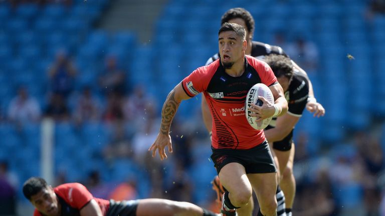 Former Salford Red Devils player Rangi Chase (centre) breaks through the tackles of Widnes Vikings' Jon Clarke and Magraff Leuluai to score