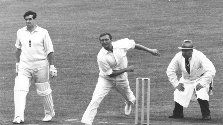 Richie Benaud of Australia is watched very carefully by the umpire as he bowls on the first day of the first England v Australia