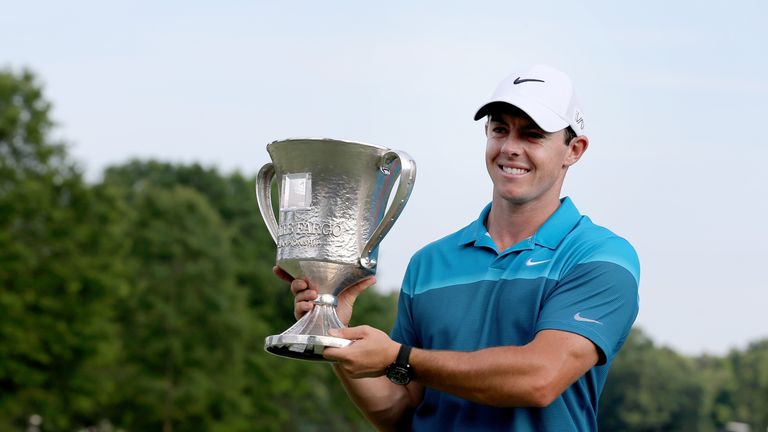 Rory McIlroy of Northern Ireland poses with the trophy after his win on the 18th hole 