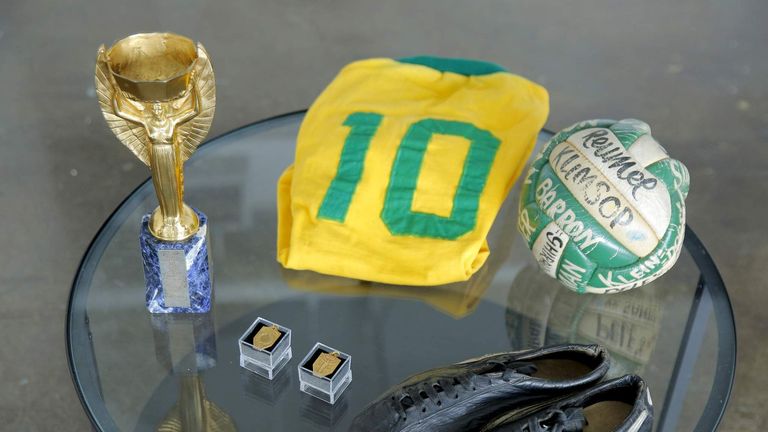 Memorabilia to be auctioned off by legendary Brazilian soccer player Pele, including a 1958 World Cup trophy, rests on a table.