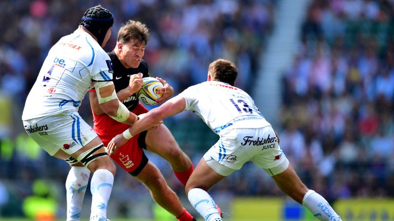 Schalk Brits (C) of Saracens is tackled by Mitch Lees (L) and Henry Slade (R) of Exeter Chiefs