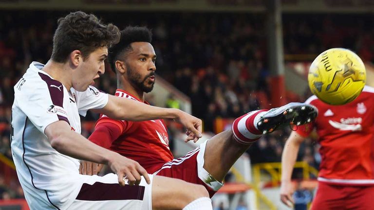 Shay Logan (centre) battles for the ball with Hearts' Dario Zanatta
