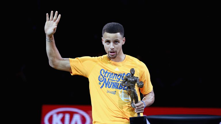 Stephen Curry #30 of the Golden State Warriors lifts up his MVP trophy before their game against the Portland Trail Blazers in Game 
