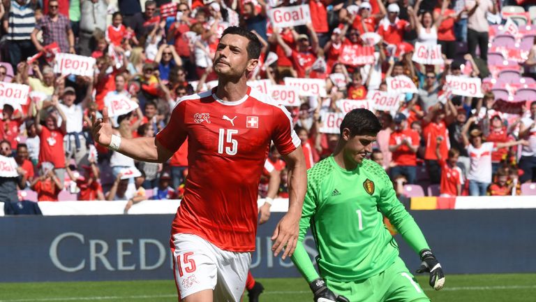 Switzerland's midfielder Blerim Dzemaili (L) reacts after scoring next to Belgium's goalkeeper Thibaut Courtois (down) during the friendly football match b