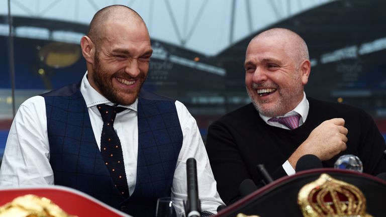 Tyson Fury (L) and Peter Fury share a joke at a press conference