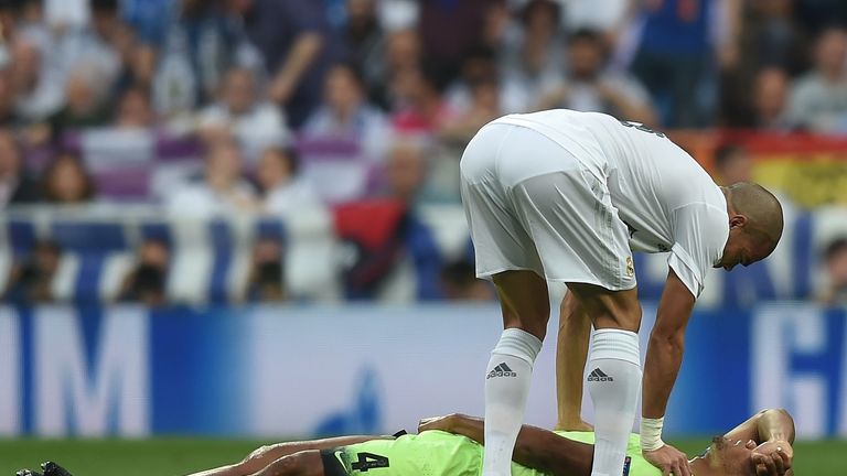 Pepe of Real Madrid checks on the injured Vincent Kompany