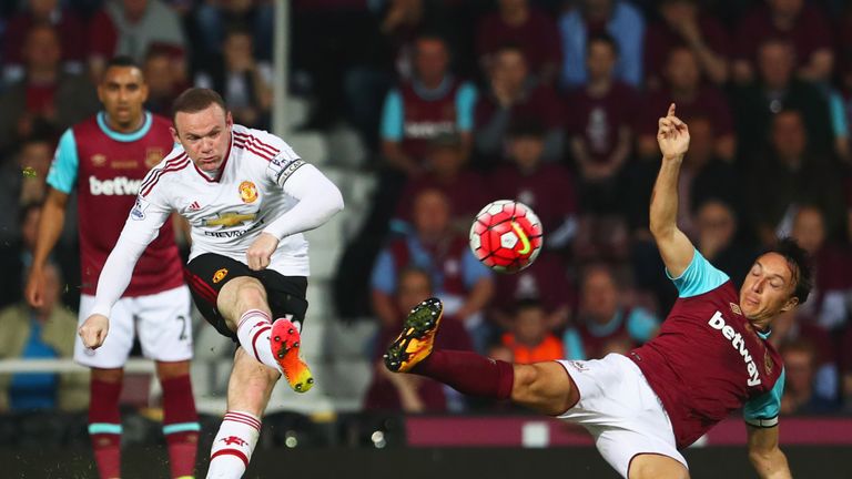Wayne Rooney of Manchester United shoots past Mark Noble of West Ham United during the Premier League match between West Ham and Man Utd