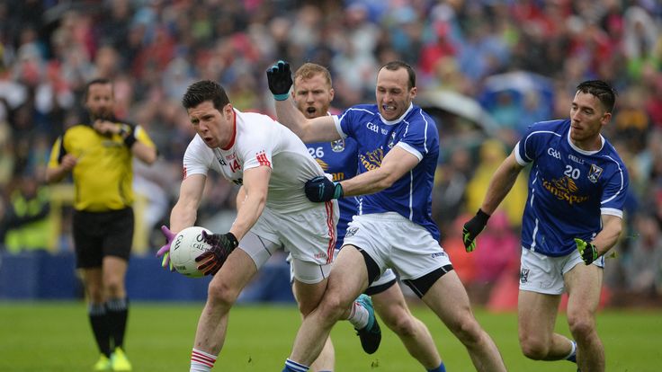 Sean Cavanagh of Tyrone is tackled by Cavan's Feargal Flanagan