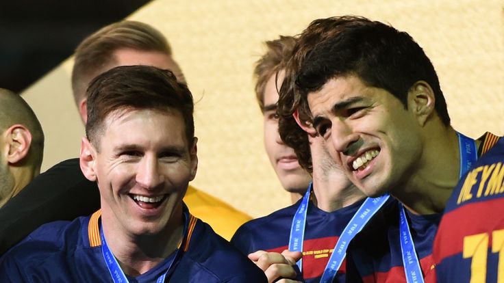 Barcelona forward Lionel Messi (L) smiles beside forward Luis Suarez (R)