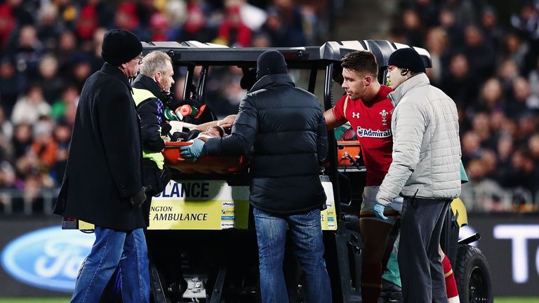 Aaron Cruden of New Zealand is taken off the field with an injury as Rhys Webb of Wales wishes him the best 