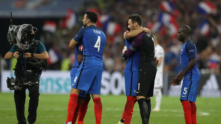 France's defender Adil Rami hugs a team-mate as they celebrate their 2-0 win over Albania