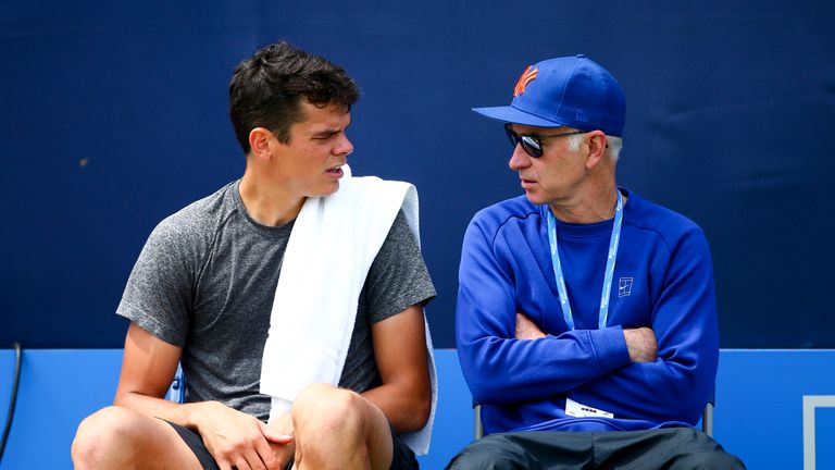 Milos Raonic of Canada (L) sits with his coach John McEnroe (R) during a practice session