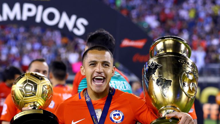 Alexis Sanchez celebrates with the Copa America trophy (R) and the Player of the Tournament award