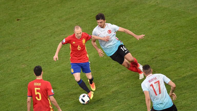 Spain's midfielder Andres Iniesta and Turkey's midfielder Ozan Tufan vie for the ball