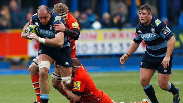 CARDIFF, WALES - FEBRUARY 07: Lou Reed of Cardiff is tackled by Jamie Gibson (2L) and Neil Briggs of Leicester during the LV= Cup match between Cardiff Blu