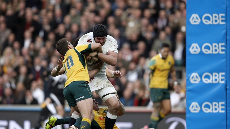 England's number 8 Ben Morgan (C) holds on to the ball as Australia's fly half Bernard Foley (L) tries to rip the ball away as he runs toward the try line 