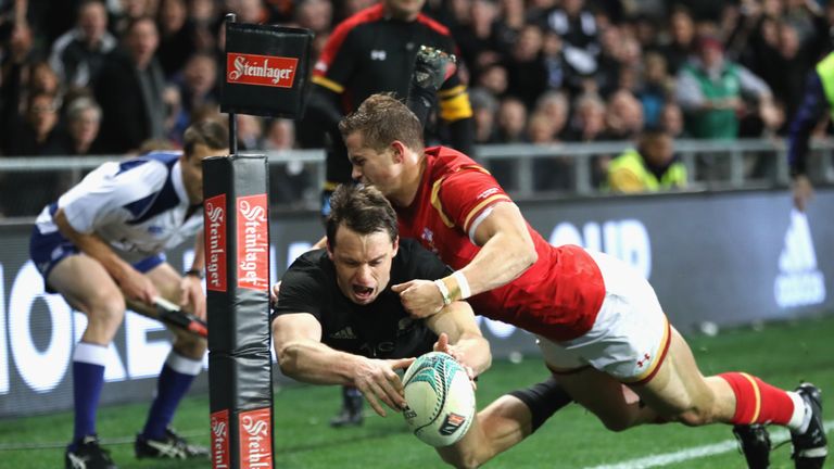 Ben Smith of the All Blacks scores a try in the tackle of Hallam Amos of Wales