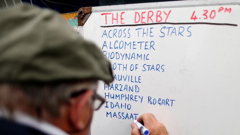 A bookmaker marks up the runners for the Investec Derby