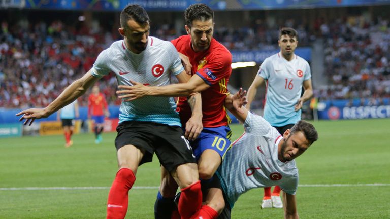 From left, Turkey's Mehmet Topal, Spain's Cesc Fabregas and Turkey's Hakan Calhanoglu fight for the ball during the 
