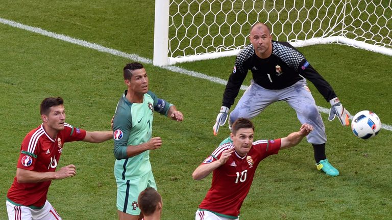 Portugal's forward Cristiano Ronaldo (C) and Hungary's midfielder Zoltan Gera look at the ball