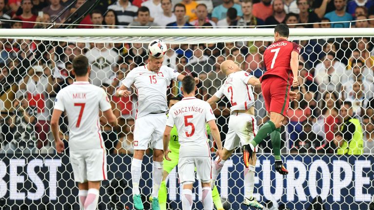 Cristiano Ronaldo (R) jumps for the ball with Poland's defender Kamil Glik (2L)