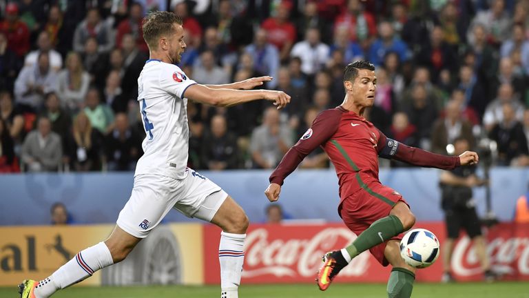 Iceland's defender Kari Arnason (L) vies for the ball against Portugal's forward Cristiano Ronaldo during the Euro 2016 group F football match between Port