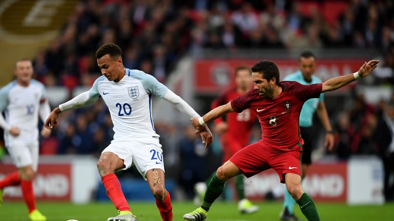 Dele Alli of England holds off Joao Moutinho of Portugal during the international friendly match between England and Portugal a