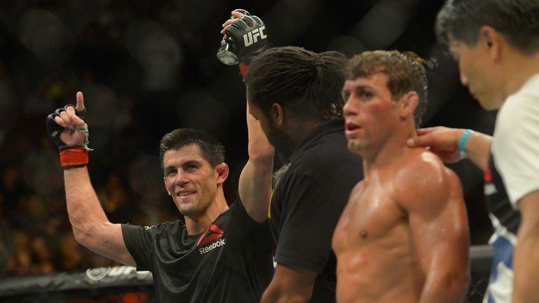 Referee Herb Dean raises the arms of Dominick Cruz (red gloves) after he defeated Urijah Faber (blue gloves) in their bantamweigh