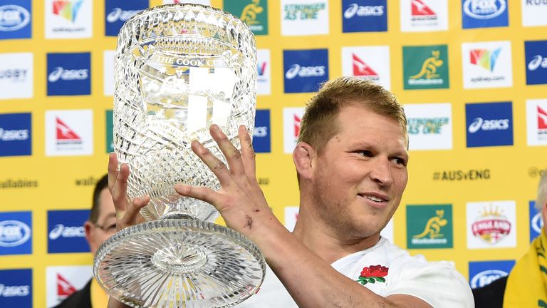 England's captain Dylan Hartley (C) lifts a winning trophy following their victory over Australia in the third and final rugby union Test match in Sydney o