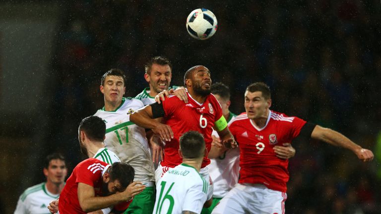 Ashley Williams of Wales heads the ball clear under pressure from Paddy McNair and Gareth McAuley of Northern Ireland during th