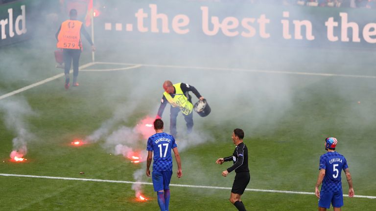 Flares are thrown on the pitch during the Euro 2016 Group D match between Czech Republic and Croatia