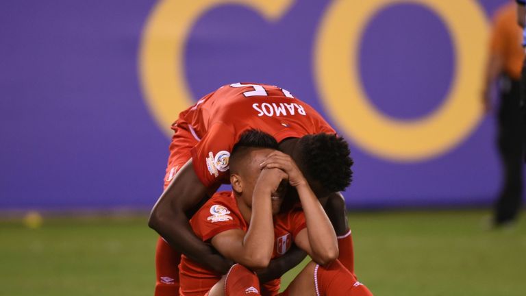 Peru's Christian Cueva (sitting) is comforted by teammate Christian Ramos as he cries inconsolably after missing his shot in the penalty shoot-out