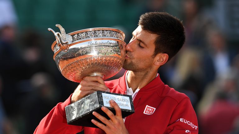 Novak Djokovic kisses the trophy following his victory during the Men's Singles final match against Andy Murray