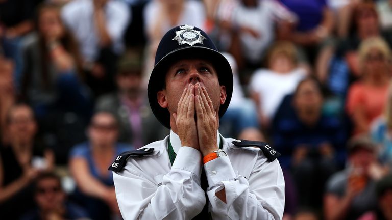 A policeman reacts as he watches the Wimbledon final  between Novak Djokovic and Roger Federer