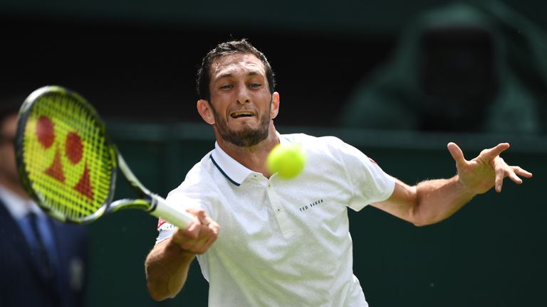James Ward of Great Britain plays a forehand shot during the Men's Singles first round  against Novak Djokovic of Serbia on day one at Wimbledon
