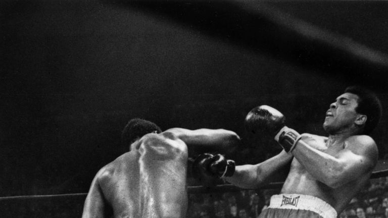 Joe Frazier lands on Muhammad Ali (R) with a right