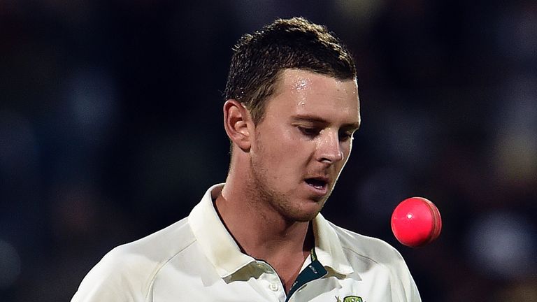 Australia's paceman Josh Hazlewood tosses the pink ball between deliveries in the first day-night Test