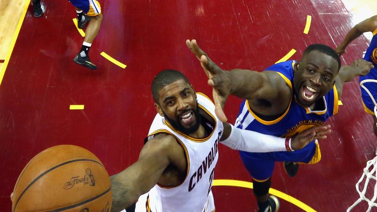 Cleveland's Kyrie Irving drives to the basket under pressure from Draymond Green
